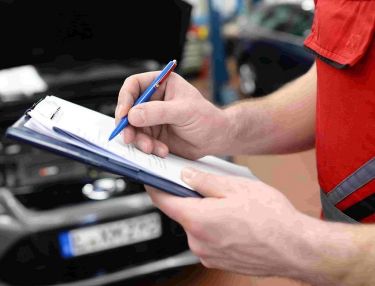 un homme tenant un stylo et écrivant sur une feuille de papier