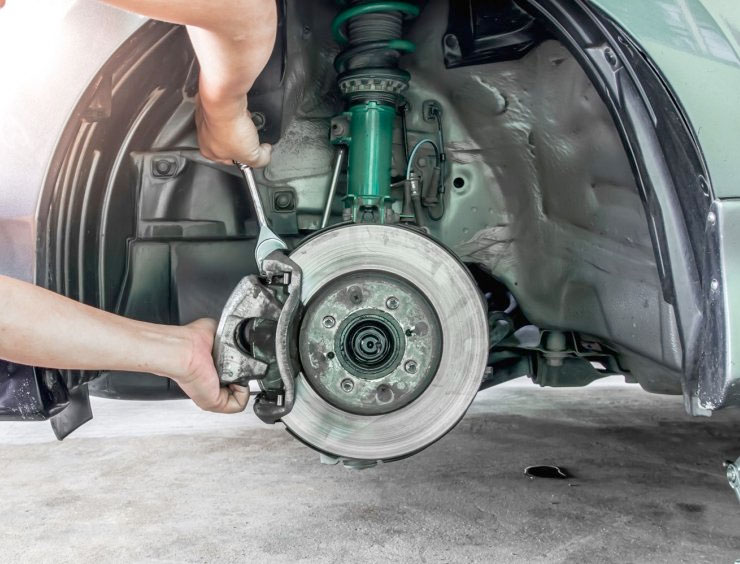 une personne travaillant sur un ensemble de freins sur une voiture