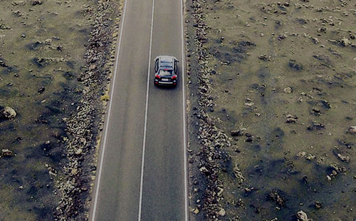 une voiture roulant sur une route au milieu de nulle part
